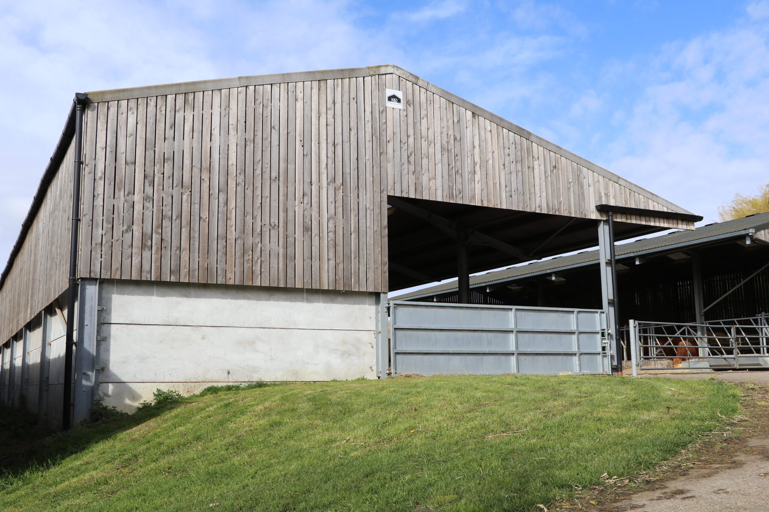 A cattle shed made out of concrete and wood